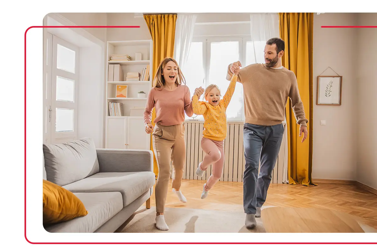 Mother and father swinging their daughter while playing in their home living room