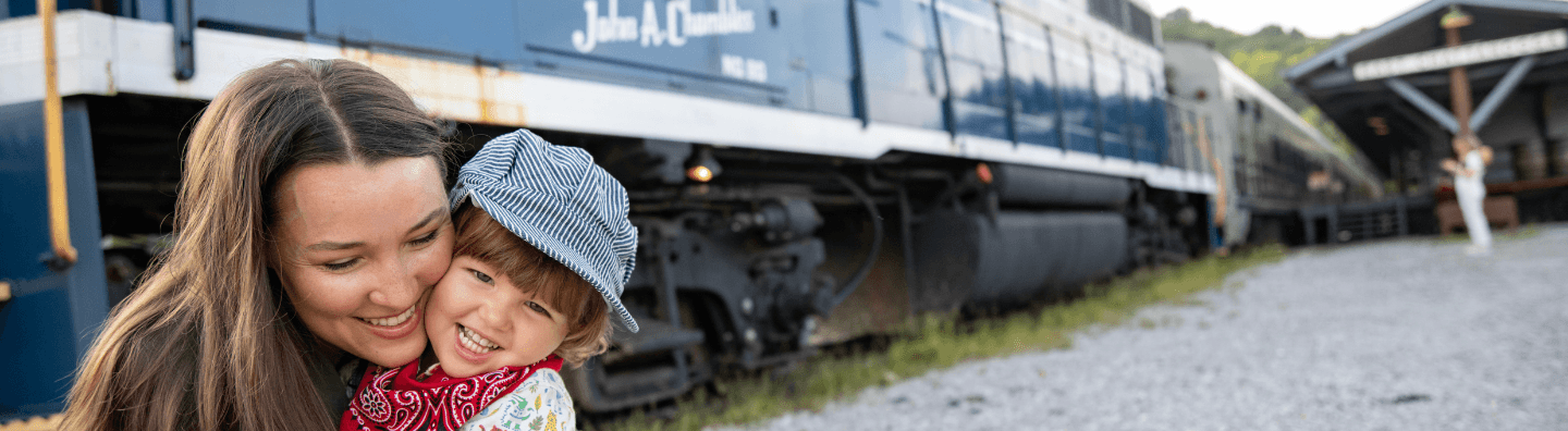 Woman hugging child in front of train